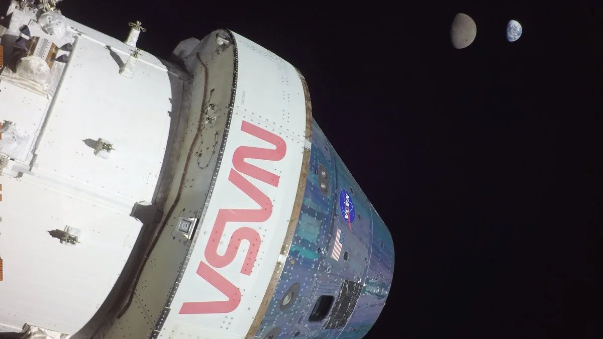 NASA's Orion spacecraft in deep space with the Earth and Moon visible in the background, photographed during the Artemis I mission