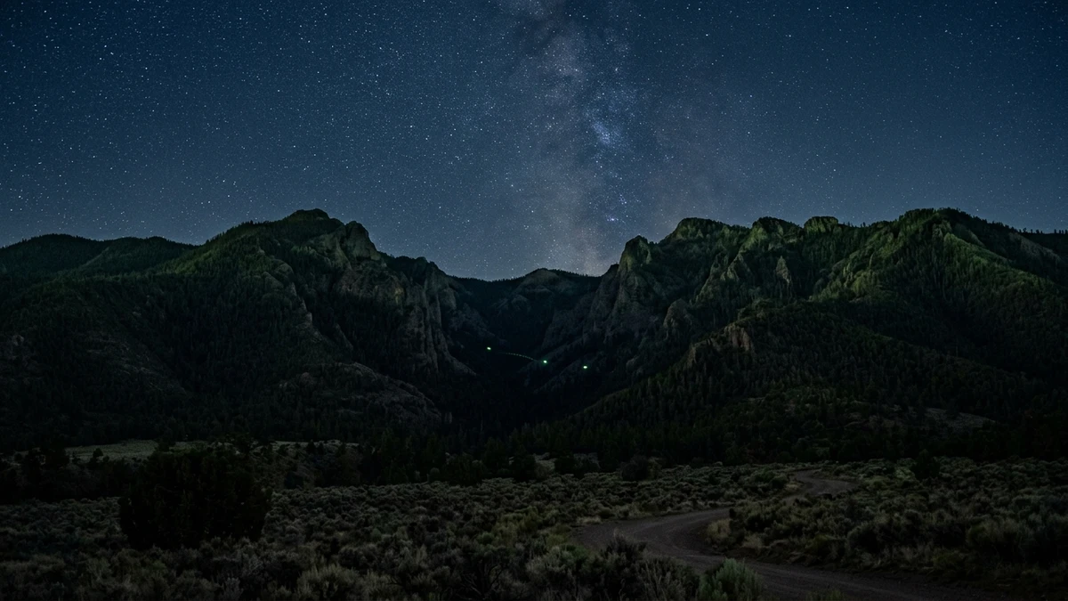 Artist's impression of a green fireball moving horizontally over the Jemez Mountains near Los Alamos at night