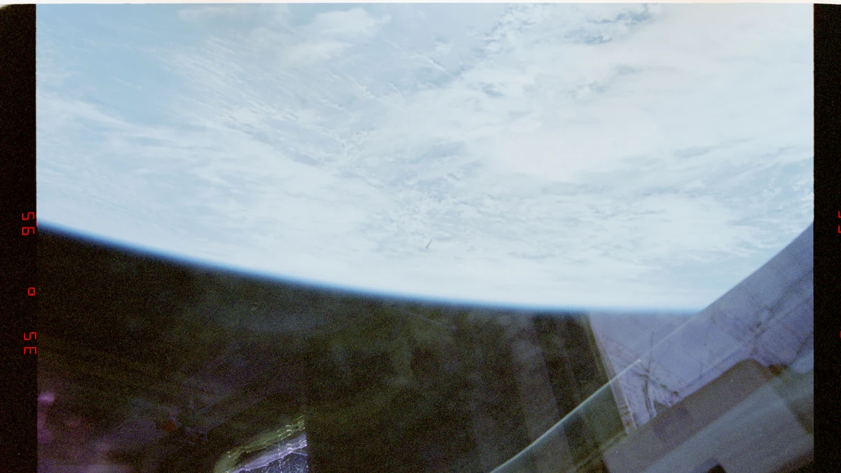 Third NASA STS-80 photograph: the unidentified object seen against the cloud tops of Earth, passing between Columbia and the surface