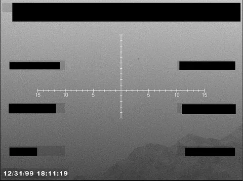 Redacted sensor image with a targeting reticle.
